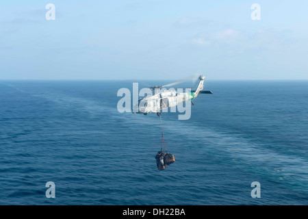 Ein MH-60 Seahawk Hubschrauber zugewiesen, die staubigen Hunde der Hubschrauber Meer bekämpfen Squadron (HSC) 7 liefert Fracht auf dem Flugzeugträger USS Harry S. Truman (CVN-75). Truman, Flaggschiff der Harry S. Truman Carrier Strike Group, ist auf t bereitgestellt. Stockfoto