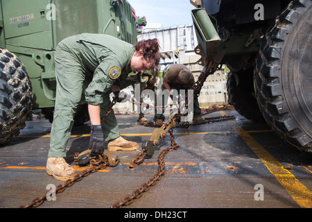 Rumpf-Techniker 3. Klasse Brianna Young von Assault Craft Einheit (ACU) 4 sichert ein leichtes gepanzertes Fahrzeug (LAV) auf ein Landungsboot Luftkissen (STERNS) angebracht zu den amphibischen Angriff Schiff USS Kearsarge (LHD-3). Kearsarge ist als Teil der Kearsar bereitgestellt. Stockfoto