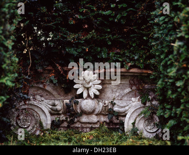 Nahaufnahme des reich verzierten Steinbank gegen Hecke im Stadtgarten Stockfoto