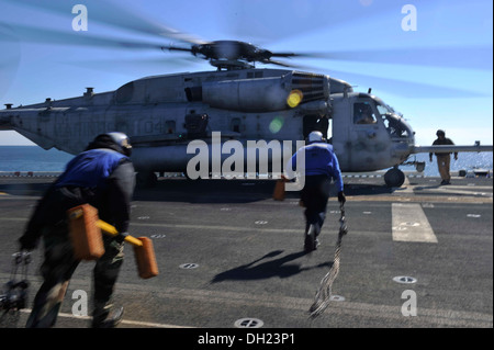 Bataan Segler bringen Unterlegkeile und Ketten für eine CH-53E Super Stallion Landung auf dem Flugdeck. Das multifunktionale amphibischer Angriff Schiff USS Bataan (LHD-5) und 22. Marine Expeditionary Unit im Gange Routine Qualifikationen führen. Stockfoto