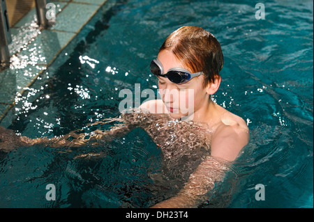 Junge, Schutzbrillen Schwimmer, 12 oder 13 Jahren mit dem Schwimmen in einem Schwimmbad Stockfoto