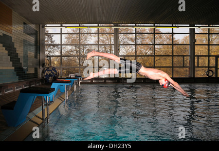 Junge, Schwimmer, 12 oder 13 Jahren aus dem Startblock in den Pool springen Stockfoto