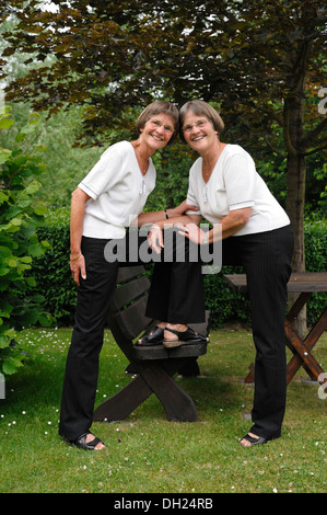 Im Garten stehen zwei rüstige Zwillingsschwestern Stockfoto