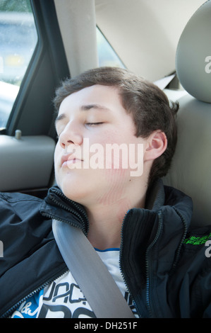 Kleiner Junge schlafend im Rücksitz des Wagens voll Modell veröffentlicht Stockfoto