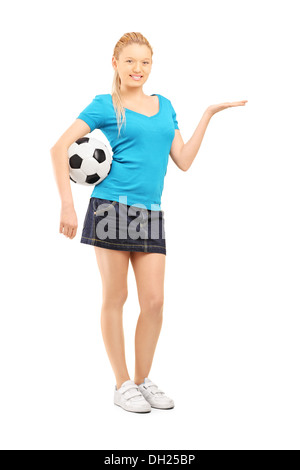 Voller Länge Porträt einer jungen Frau hält einen Fußball und Gestikulieren Stockfoto