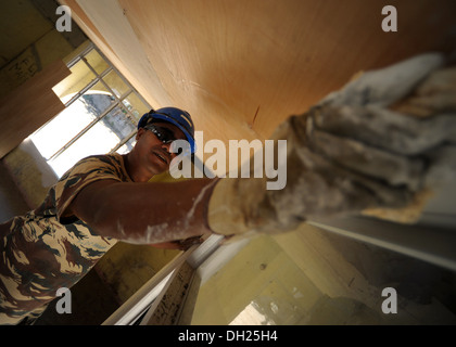 DILI, Osttimor – (25. Oktober 2013) Timor-Leste Defense Force (F-FDTL) Ingenieur Soldat Leandro Carvalho imprägniert ein Fenster er Stockfoto