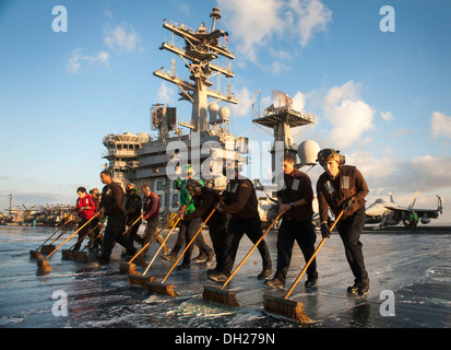 Seeleute schrubben das Flugdeck des Flugzeugträgers USS Nimitz (CVN-68). Nimitz bereitgestellt wird, Unterstützung der Sicherheit im Seeverkehr Oper Stockfoto