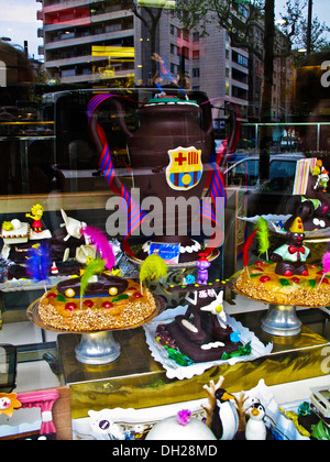Eine Auswahl an Kuchen, Gebäck und Schokolade auf einem Display-Zähler in einem Schaufenster Stockfoto