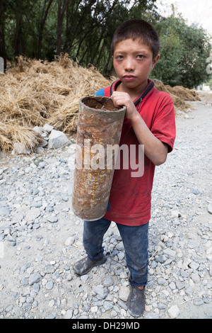 Indische muslimische Kinder spielen mit der indischen Armee Artillerie Patronenhülsen nahe der pakistanischen Grenze. Turkuk, Ladakh, Indien Stockfoto