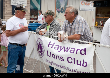 Männer im Gespräch trinken Bier im Freien vom Lions Club anmelden beim Moschus Festival Hayward Wisconsin WI USA Stockfoto