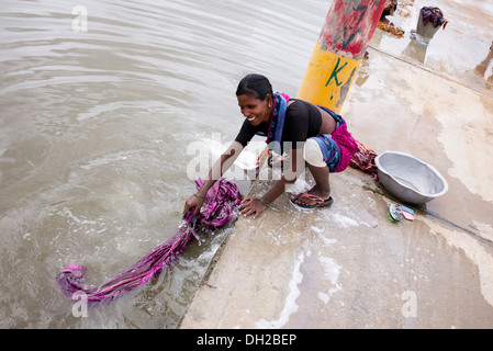 Indische Frau Wäsche von hand neben einem Fluss. Andhra Pradesh, Indien Stockfoto