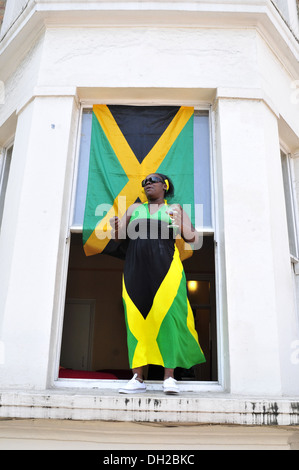 Eine Frau trägt eine Kleid jamaikanische Flagge auf dem Notting Hill Carnival in London Stockfoto