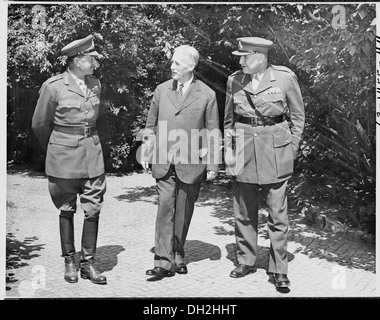 Ein historisches Foto, das (von links nach rechts) Feldmarschall Sir Harold Alexander, Oberbefehlshaber des Mittelmeertheaters, US-Kriegsminister Henry Stimson und eine unbenannte Militärfigur zeigt, wahrscheinlich während der Diskussionen im Zweiten Weltkrieg. Stockfoto
