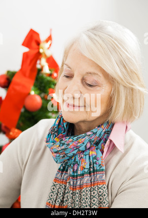 Ältere Frau vor Weihnachtsbaum Stockfoto