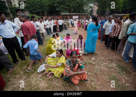 Indische Männer und Frauen sitzen und in Warteschlange für Wahlen Mumbai Maharashtra Indien Asien Stockfoto