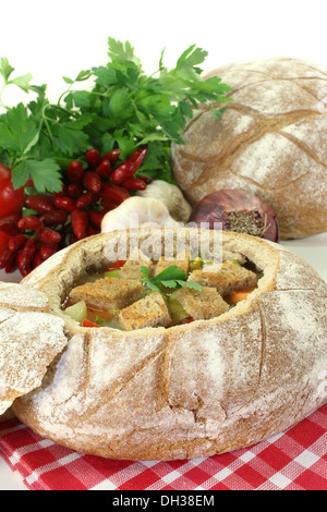 ein Bauernbrot gefüllt mit einer bunten Brotsuppe Stockfoto