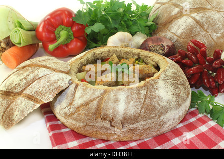 ein Bauernbrot gefüllt mit einer bunten Brotsuppe Stockfoto