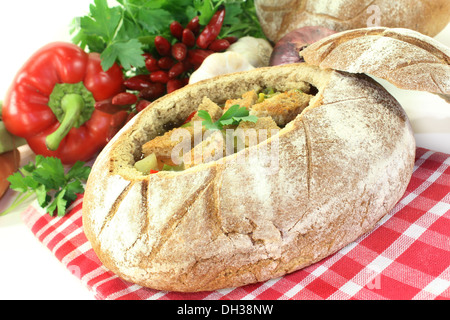 ein Bauernbrot gefüllt mit einer bunten Brotsuppe Stockfoto