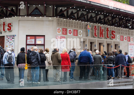 Menschen, die Schlange im Regen zu bekommen zeigen Tickets im Londoner West End Stockfoto