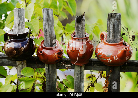 vier Keramik Teekanne auf einem hölzernen Zaun im Garten Stockfoto