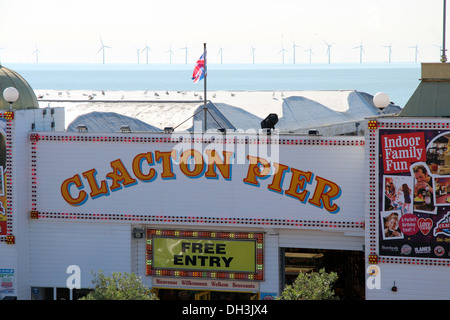 Clacton Pier Eintritt, zeigt die Windräder im Meer am Horizont. Stockfoto