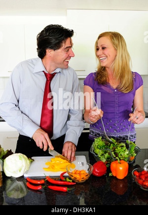 Junges Paar Schneiden von Gemüse für einen Salat Stockfoto