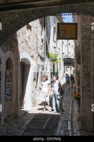 Touristen, die Surfen, vorbei an Geschäften in engen Gasse in St Paul de Vence, Frankreich Stockfoto