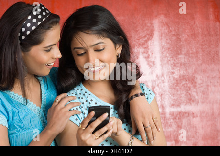Junge Frau hält eine Handy mit ihrer Freundin Stockfoto