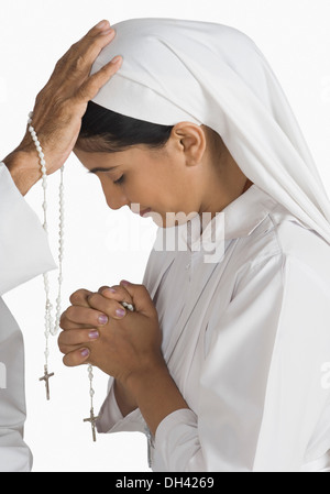 Nonne mit einem Priester ihre Sünden bekennen Stockfoto