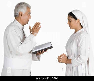 Nonne mit einem Priester ihre Sünden bekennen Stockfoto