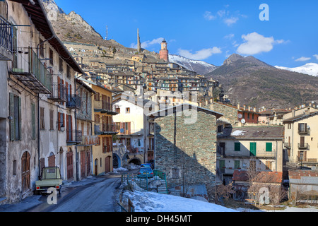 Schmale Straße zwischen alten Steinhäusern und Bergen im Hintergrund in Tende - kleine Alpenstadt auf Französisch - italienischen Grenze. Stockfoto