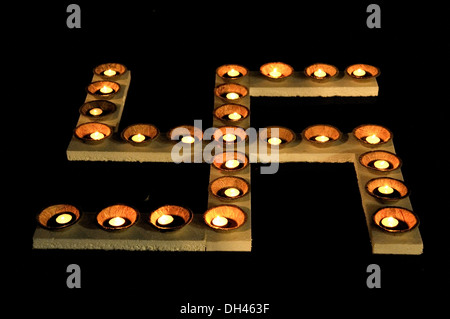 Öl-Lampen brennen auf Swastik symbol Mumbai, Maharashtra, Indien Stockfoto