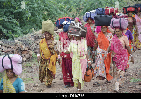 Indische Frauen balancieren Gepäcktaschen am Kopf zu Fuß Padyatra Jodhpur Rajasthan Indien Asien Stockfoto