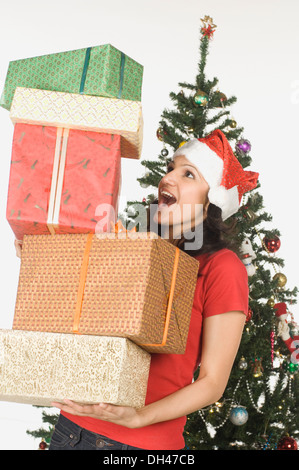 Frau mit einem Stapel von Weihnachtsgeschenken Stockfoto
