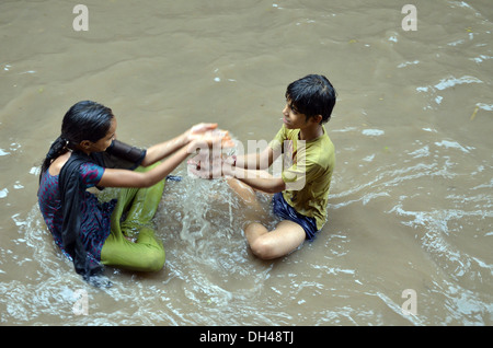 jungen und Mädchen spielen in fließenden Monsun Wasser Jodhpur Indien Stockfoto