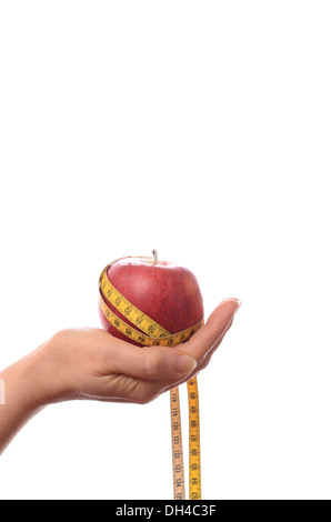 Weibliche Hand hält einen Apfel mit einem Maßband, Diät-Konzept Stockfoto