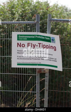 Zeichen; Lesen keine fliegen-Tipping. North Norfolk Gemeinderat. Sicherheitszaun um eine braune Wiese beigefügt. Stockfoto