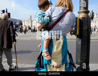 London, England, Vereinigtes Königreich. Trafalgar Square - Frau mit ihrem Sohn, warten auf die Straße zu überqueren Stockfoto