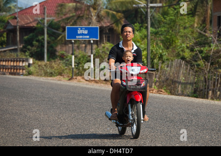 Horizontale Porträt von Vater und Sohn auf einem Moped zusammen in der Sonne. Stockfoto