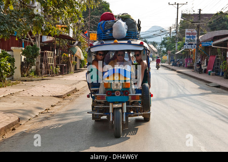 Horizontale Nahaufnahme von einem Jumbo Tuk-Tuk mit Touristen an Bord in Luang Prabang. Stockfoto