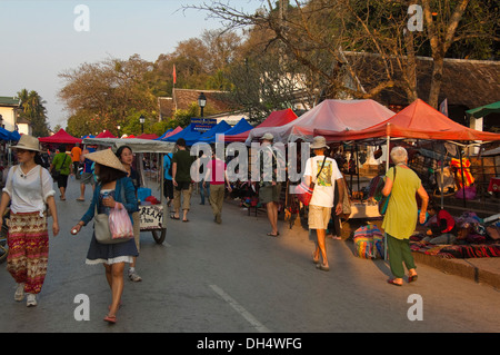 Horizontale Straßenbild Touristen zu Fuß durch den Markt in Luang Prabang bei Sonnenuntergang. Stockfoto