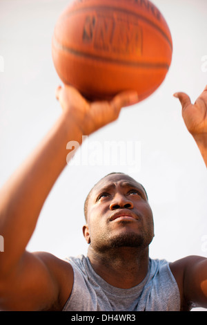 Ein Mann schießt einen basketball Stockfoto