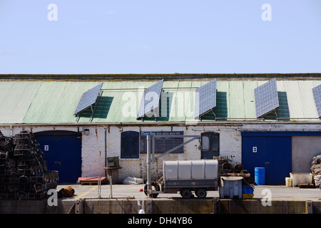 Sonnenkollektoren auf dem Dach des kommerziellen Industriebauten am Kai von Aberystwyth, Wales, UK Stockfoto