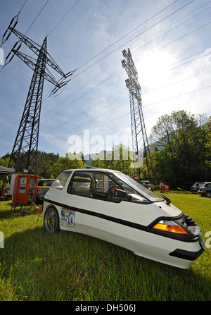 Elektro-Auto auf einer Wiese vor Strommasten, Kesselbergrennen Rennen, Kochel bin sehen, Bayern Stockfoto