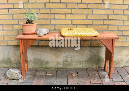 Sitzbank mit einem Kissen und einem Blumentopf Stockfoto