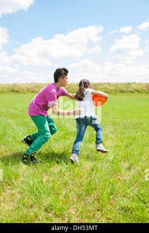 Zwei Kinder spielen Ball auf einer Wiese Stockfoto