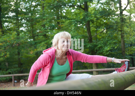 Frau erstreckt sich auf einer Outdoor-Fitness-Parcours Stockfoto