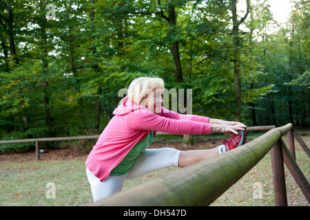 Frau erstreckt sich auf einer Outdoor-Fitness-Parcours Stockfoto