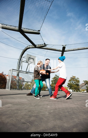 Zwei coole Jungs Basketball spielen mit ihrem Vater Stockfoto