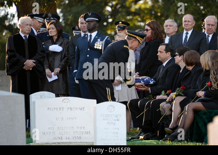 General Martin E. Dempsey, Vorsitzender der Joint Chiefs Of Staff, übergibt einen gefalteten amerikanische Flagge David Curtis Jones, Sohn von General David C. Jones, ehemaliger Vorsitzender der Joint Chiefs während seiner Beerdigung auf dem Arlington Cemetery in Arlington, VA., 25. Oktober 2013. Stockfoto